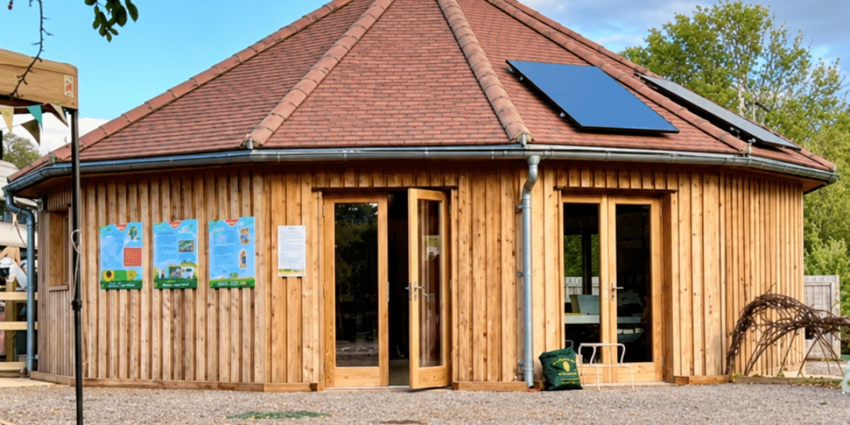 Wooden roundhouse beneath a leafy arch-2